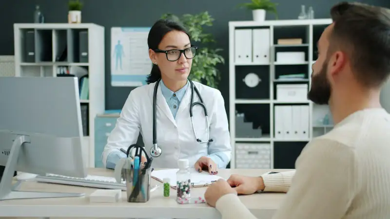 Doctor listening to a patient across the consultation desk