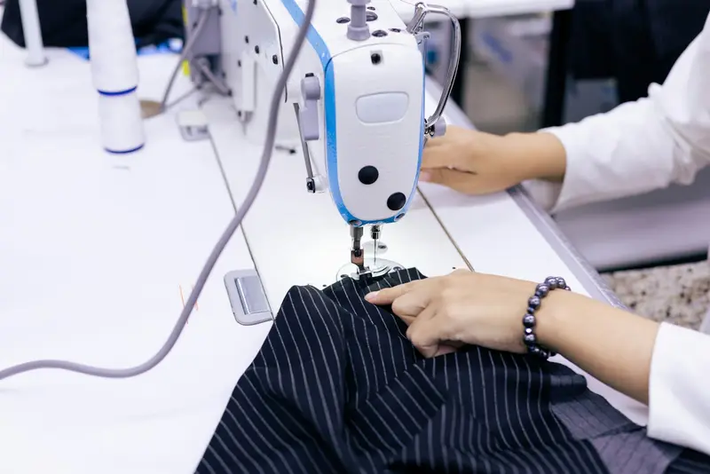 Tailor stitching a garment on a sewing machine