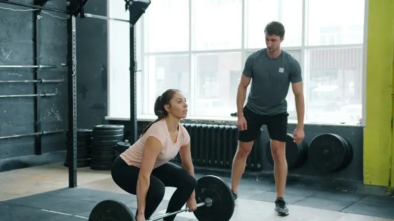 Trainer watching a member's deadlift form