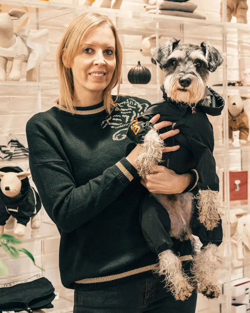 Shop owner holding a happy schnauzer inside the store