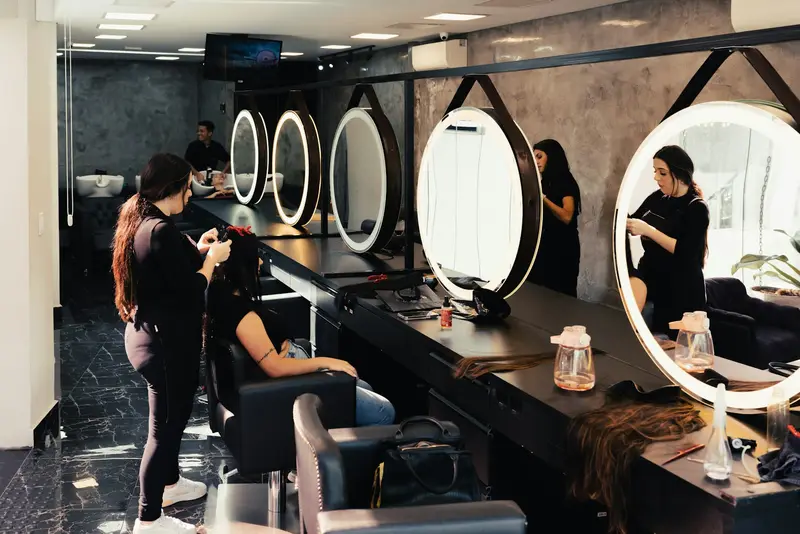 Salon floor with round lit mirrors and styling chairs